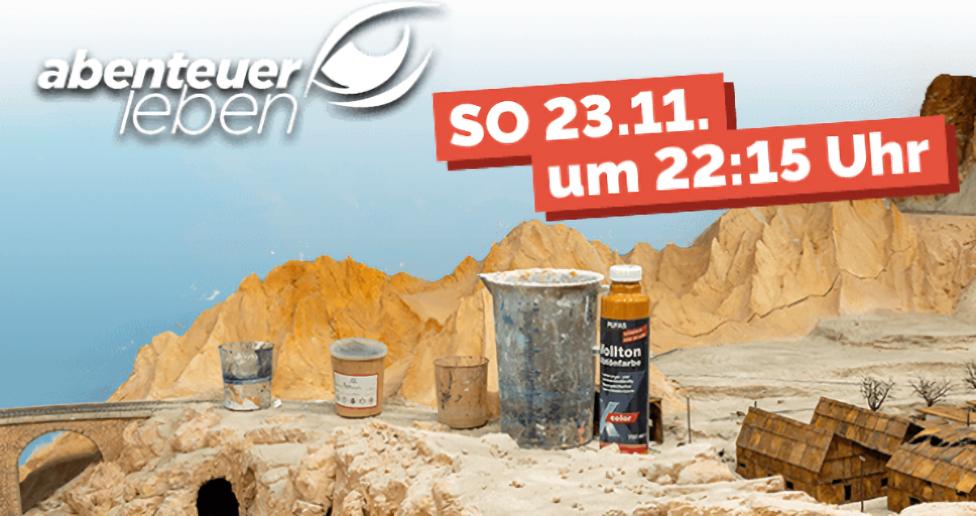 Unfertige Eisenbahnlandschaft mit Bergen und Häuser und einer Brücke und Farbflasche und Gefäßen für die Modeliermasse | Foto: Miniatur Wunderland Hamburg GmbH