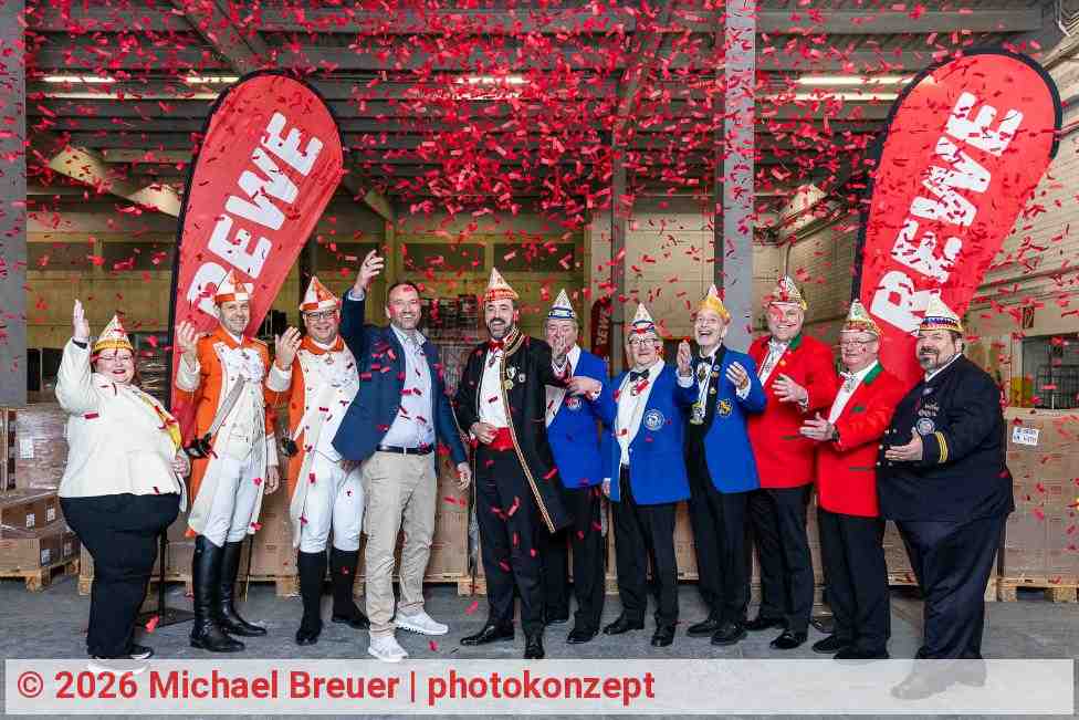 Lars Klein, Vorsitzender der Geschäftsleitung REWE Region West (4.v.l.) überreicht 32 Paletten Kamelle an Marc Michelske (5.v.l.), Zugleiter des Rosenmontagszuges und 34 Vereine. | Foto: Michael Breuer | photokonzept